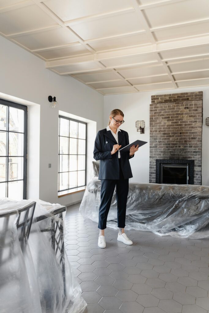 pexels-photo-7415124-7415124 Real estate agent in a suit reviewing paperwork inside a newly renovated home.